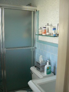 OUTDATED, BUSY TILES, OPAQUE DOORS MAKE SMALL SPACE FEEL SMALLER.